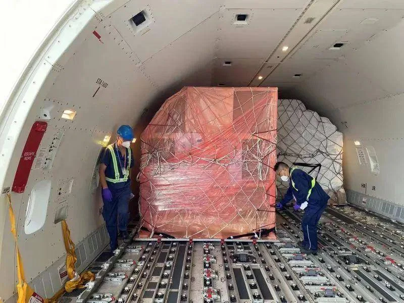 Workers loading cargo inside freighter aircraft