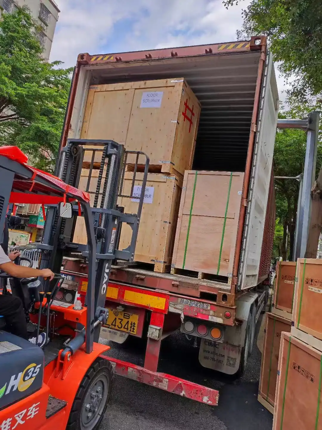 Forklift loading wooden crates into container